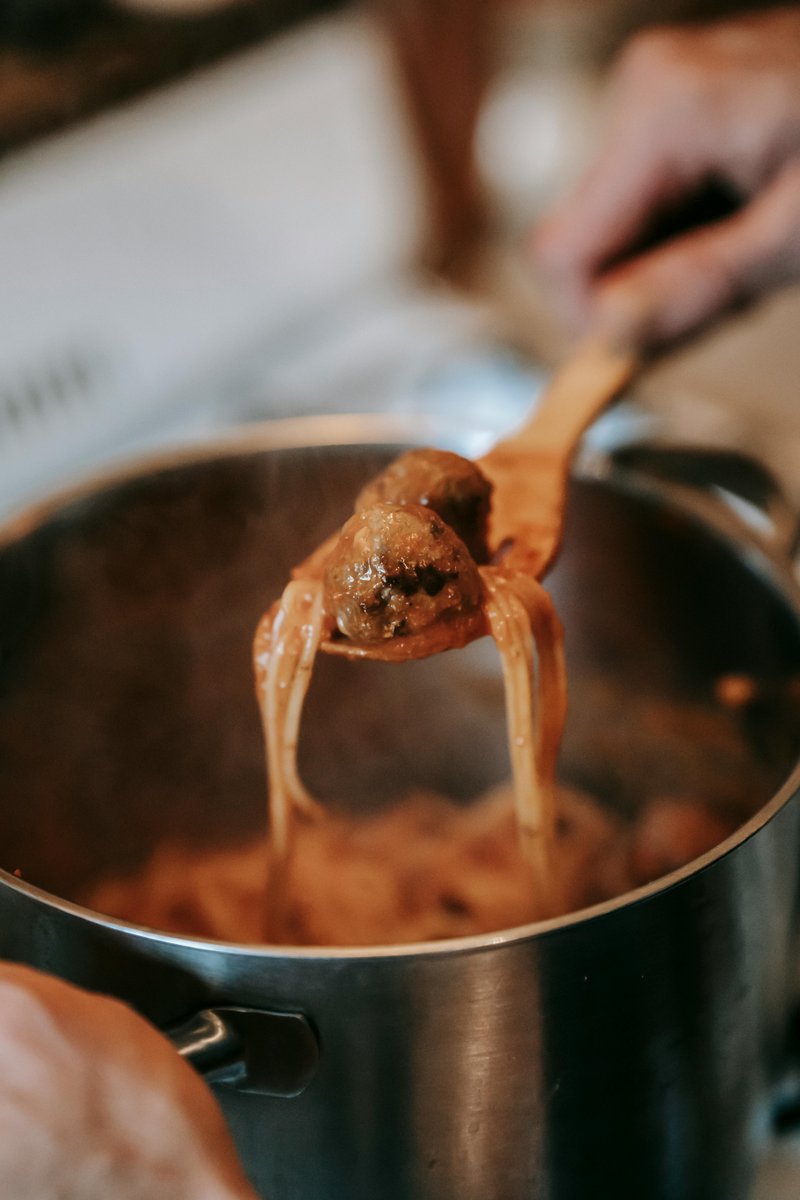 Huisgemaakte gehaktballen in tomatensaus opgeschept uit grote pot